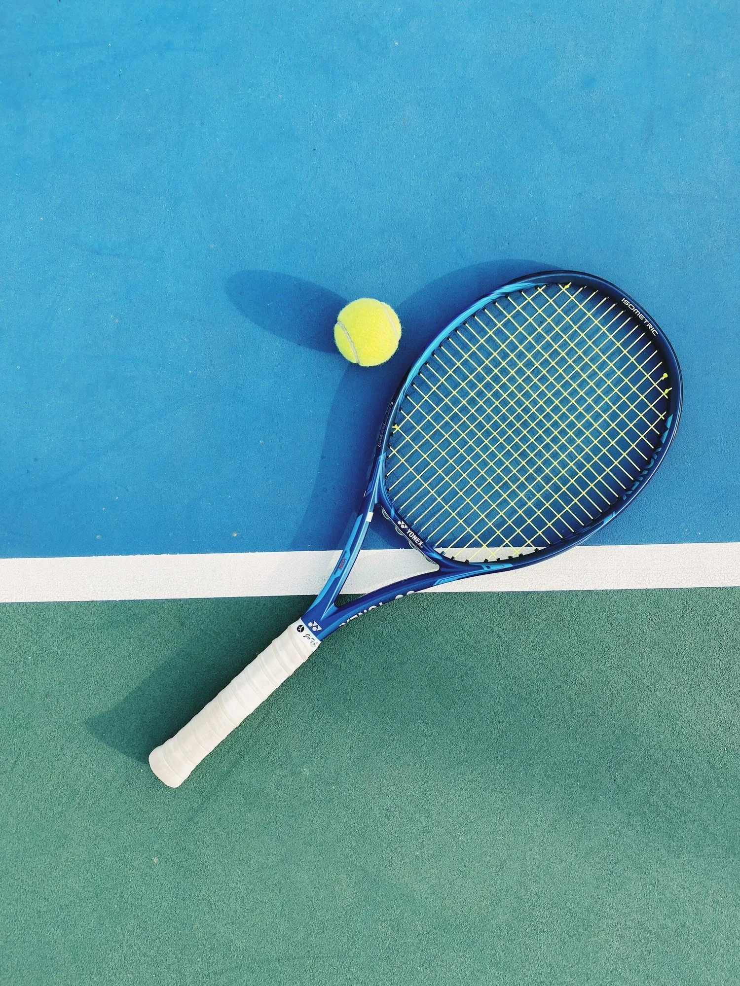 Tennis racket and ball on court