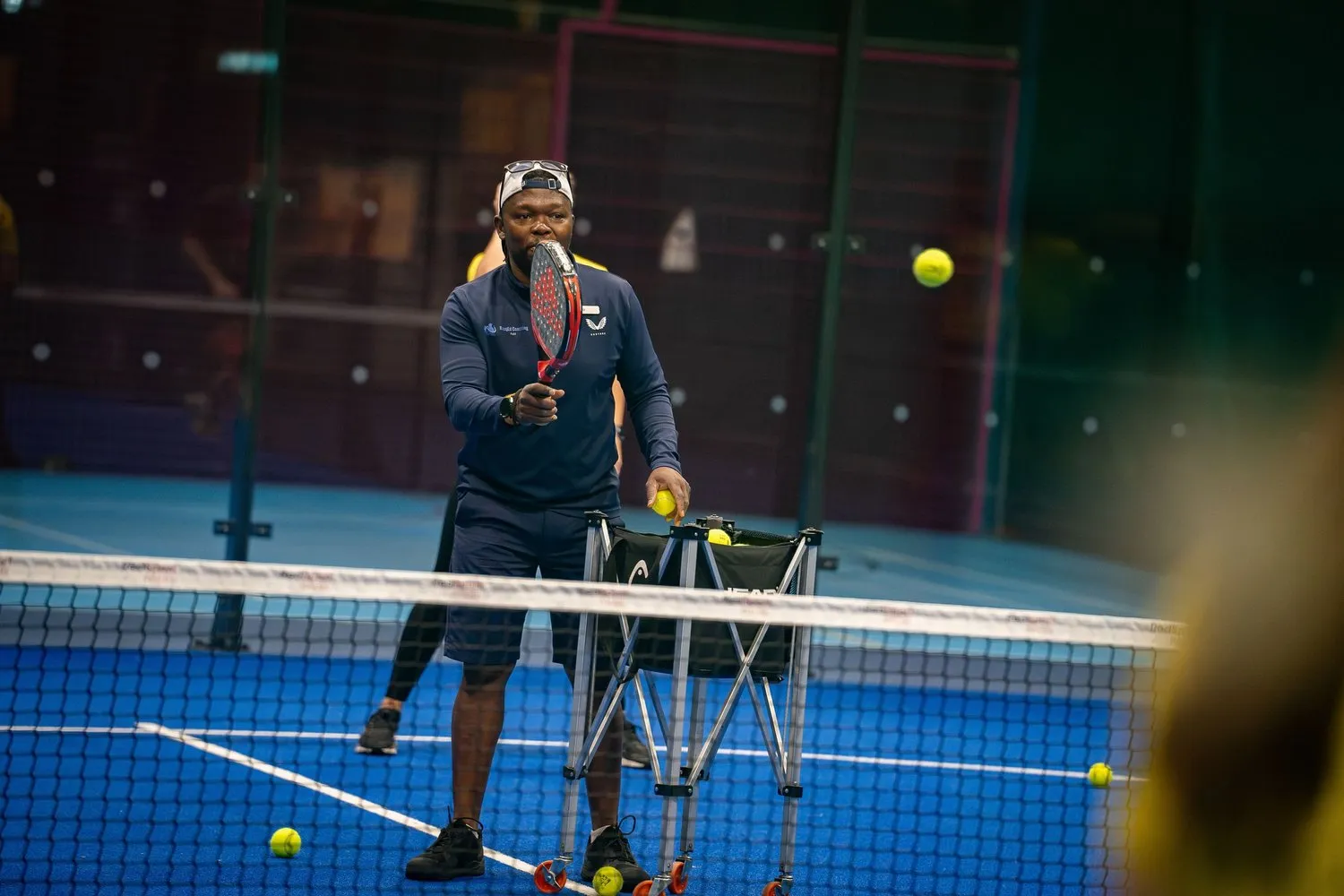 NJ feeding balls during a padel session
